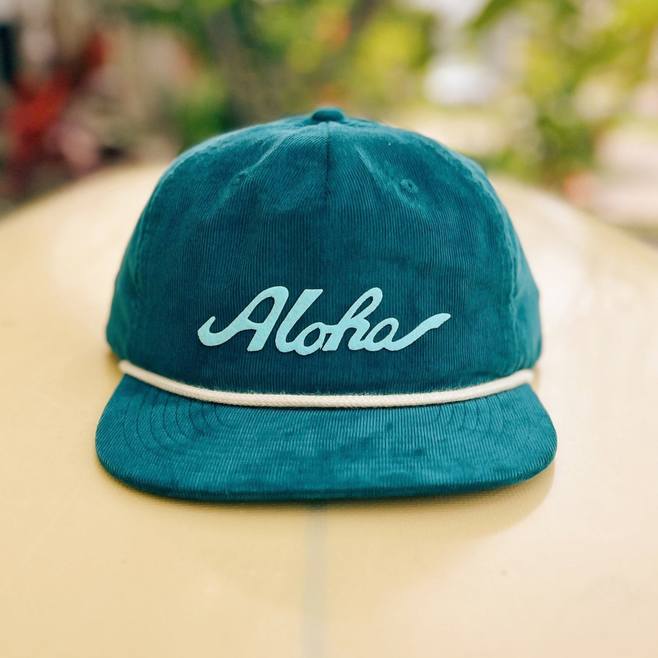 Throwback Hawaii corduroy cap with aloha script felt applique by Nick Kuchar. Available in four colors, one size fits all.