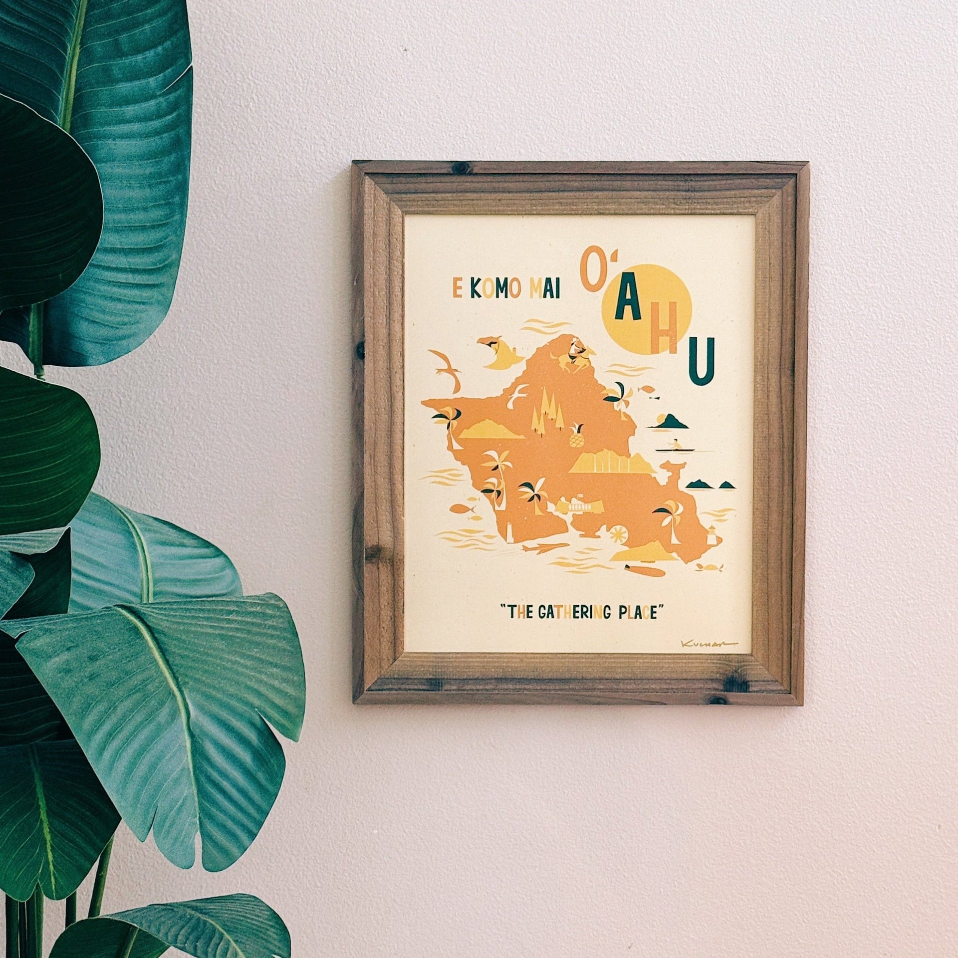 Framed map of Oahu on a wall with a plant to the left
