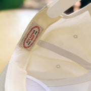 Close-up of a beige cap with a nick kuchar brand label on a blurred background