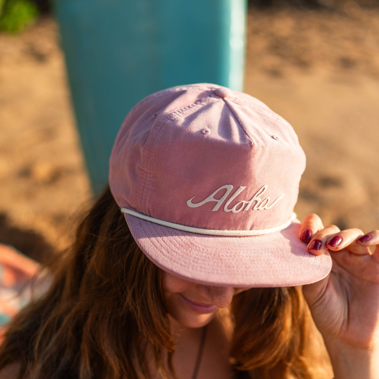 woman wearing aloha pink hat at the beach in hawaii