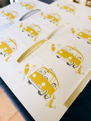 screen prints with yellow van and surf illustrations on a white background