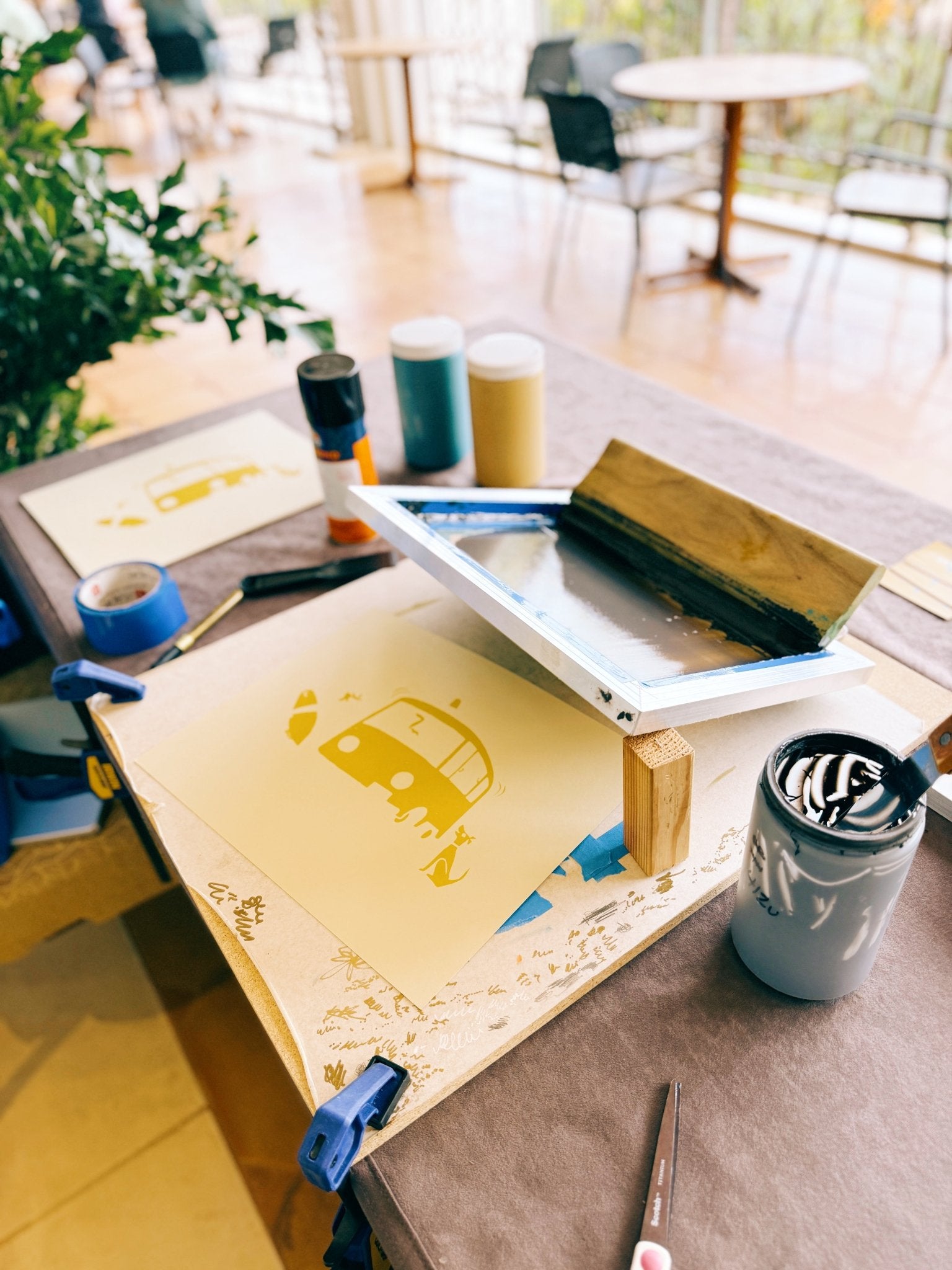 Screen printing setup on a table with ink and stencils in a casual setting