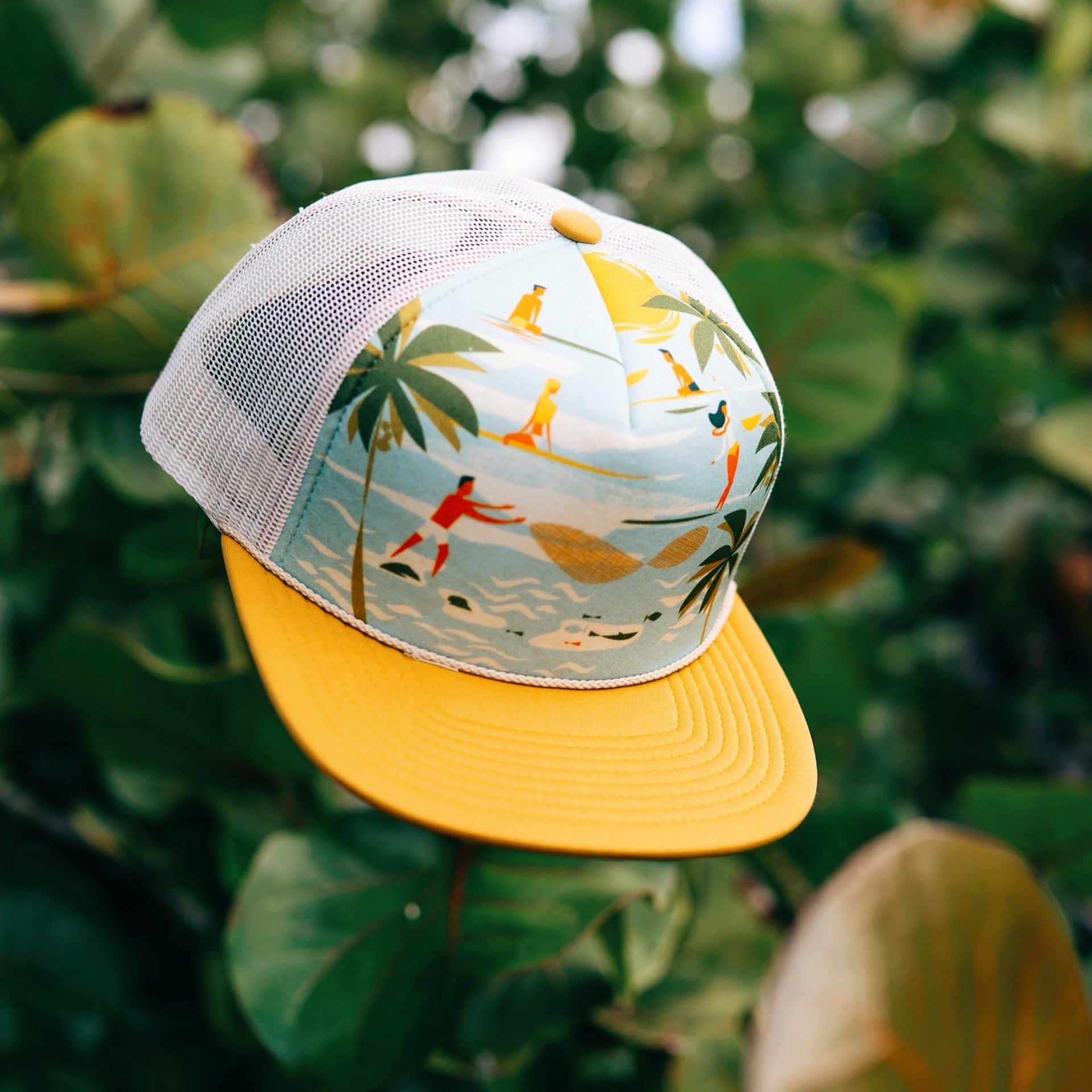 yellow foam trucker hat hanging on a tree in hawaii