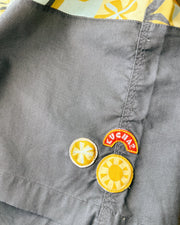 Gray brown fabric with colorful patches including a sun design and 'Kuchar' branding.