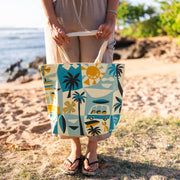 Person holding a tote bag with beach design on a beach
