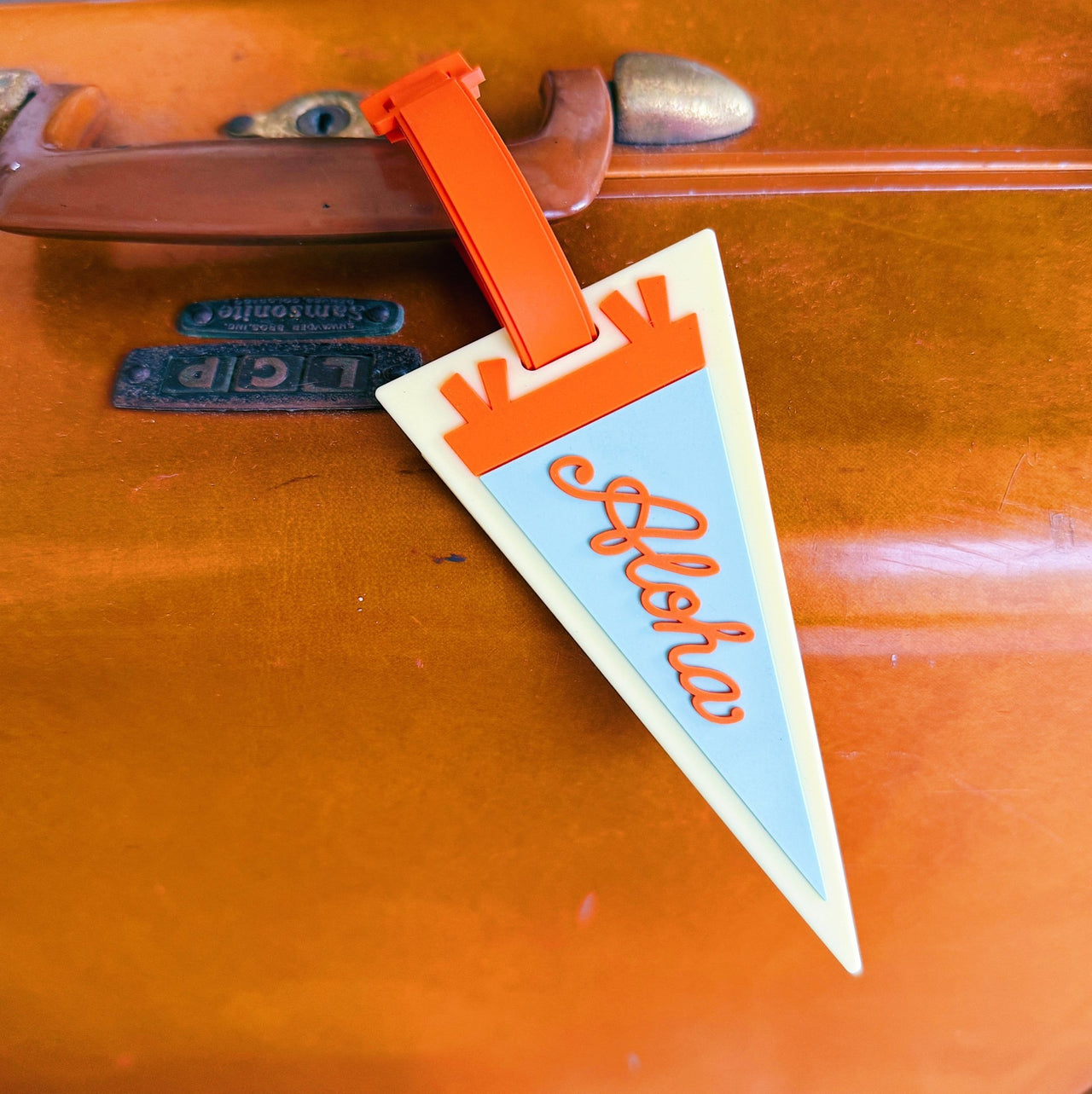 Vintage suitcase with a 'Aloha' luggage tag attached