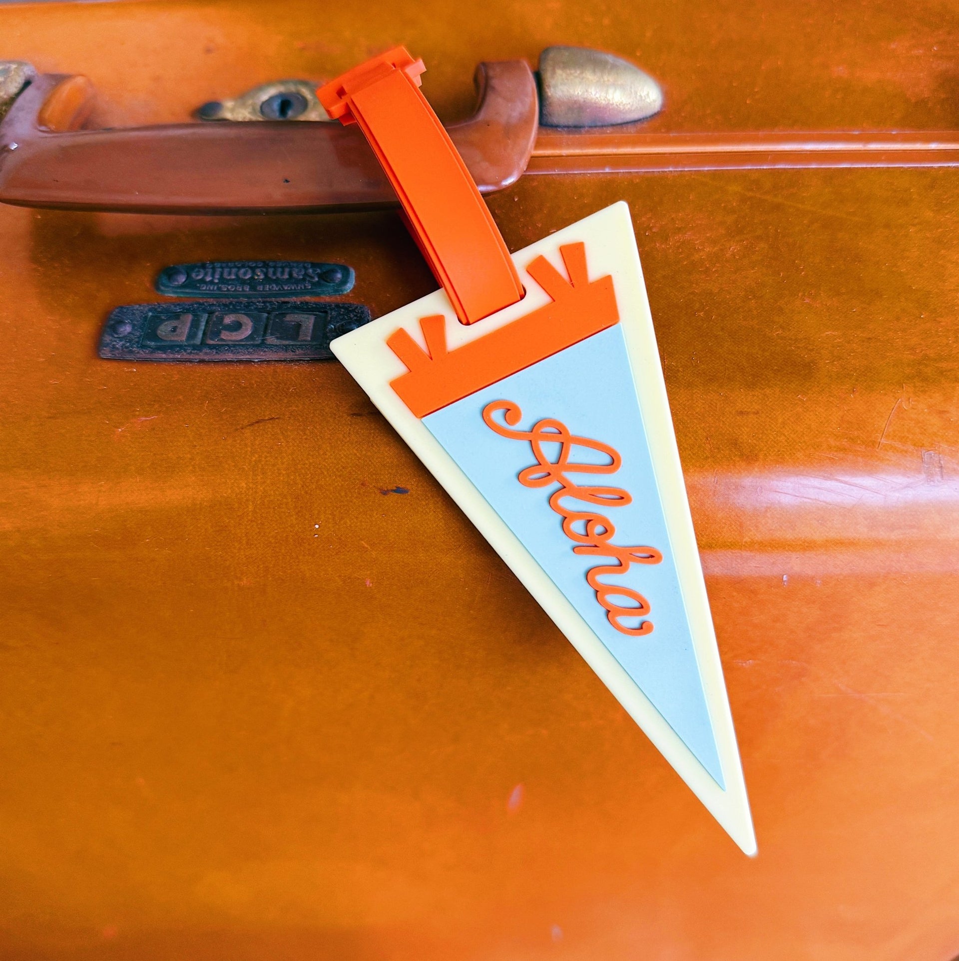 Vintage suitcase with a 'Aloha' luggage tag attached
