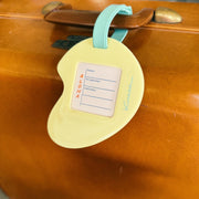 Vintage suitcase with a green luggage tag attached