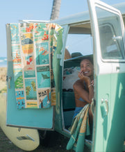 woman sitting in vintage van with microfiber beach towel at the beach in hawaii