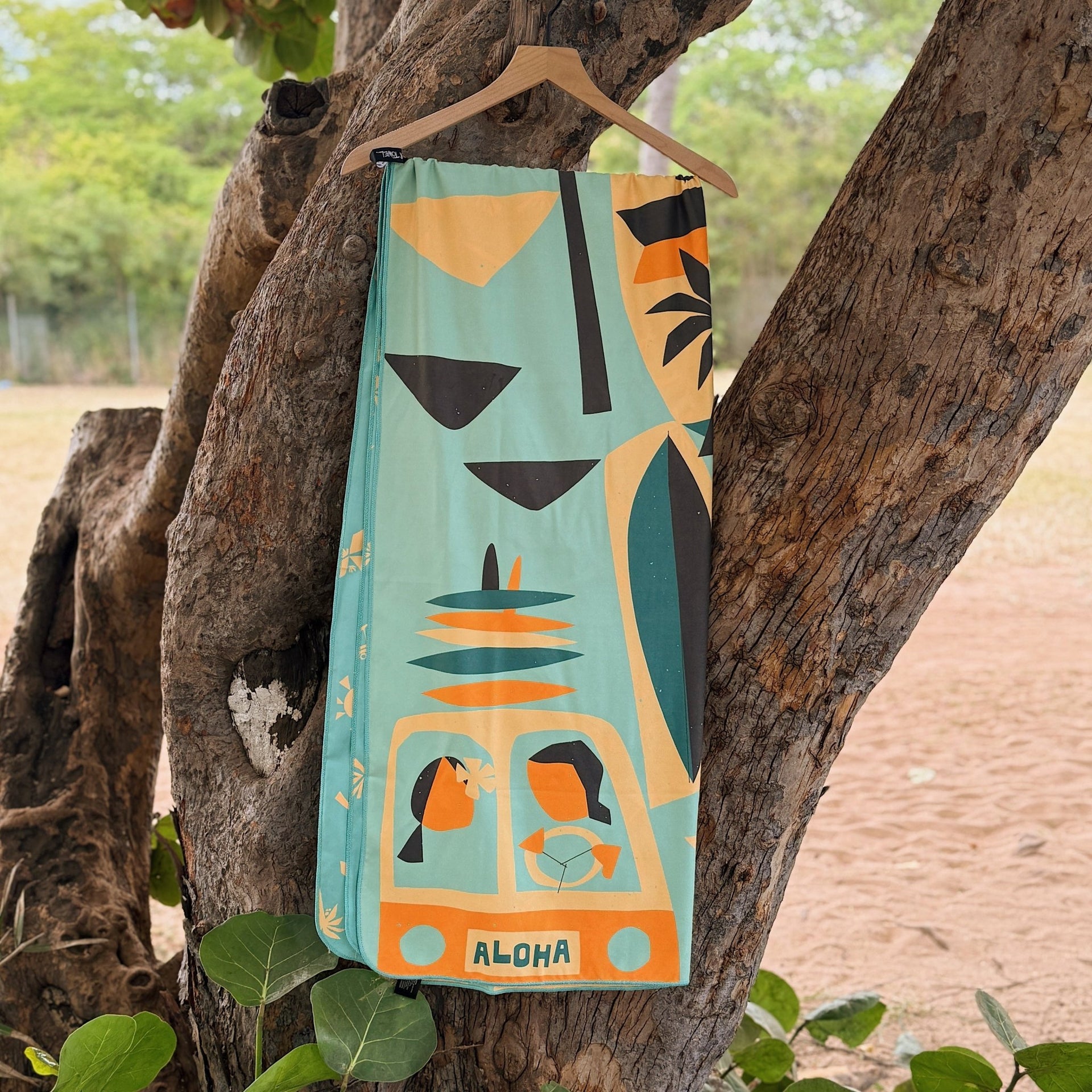Towel with a tropical design hanging on a tree branch outdoors