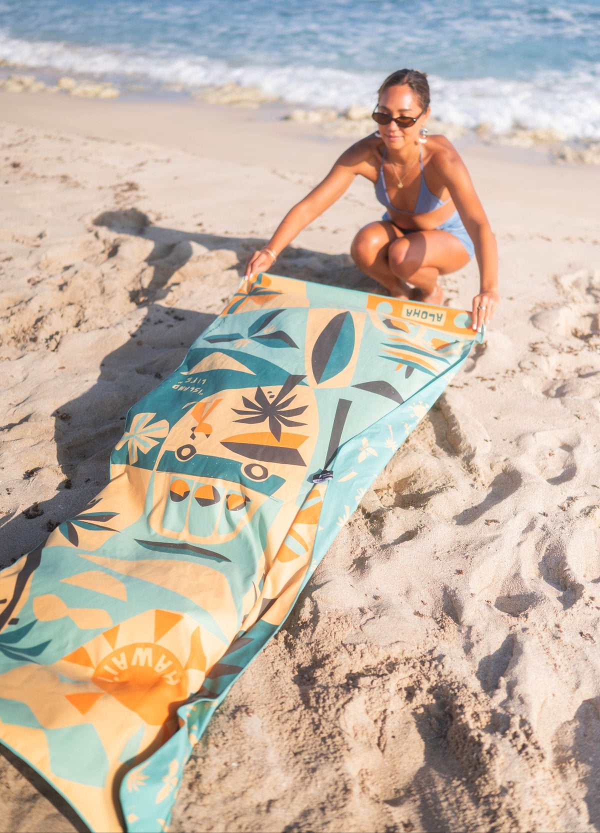 woman laying out microfiber beach towel at the beach