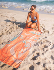 woman setting out microfiber beach towel at the beach