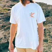 Man wearing a white Hawaii surf t-shirt with a graphic design outdoors
