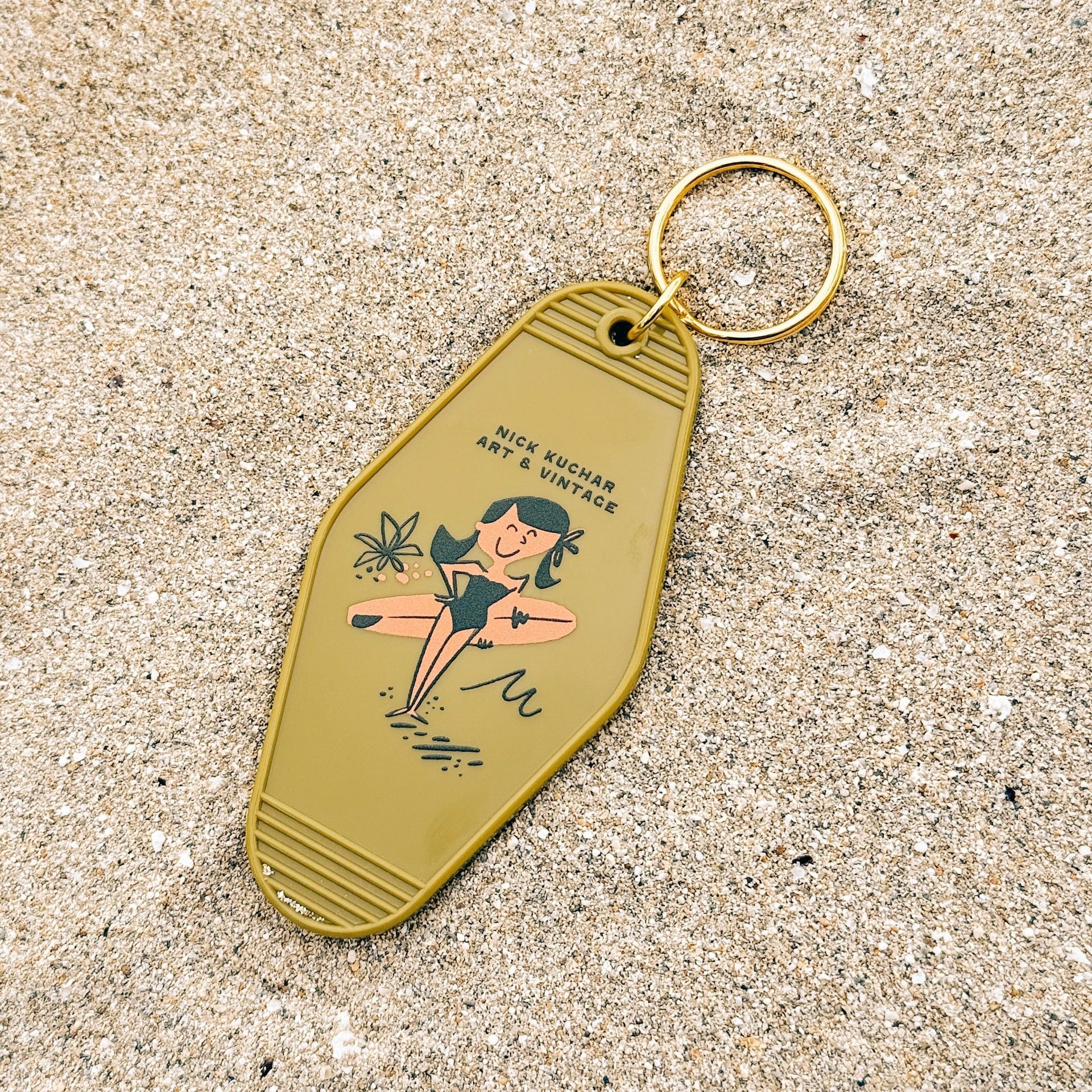 Keychain with vintage-style design on a sandy background